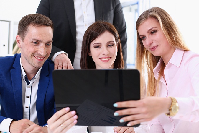 Group of people in office look at mobile tablet pc - Apac Entrepreneur